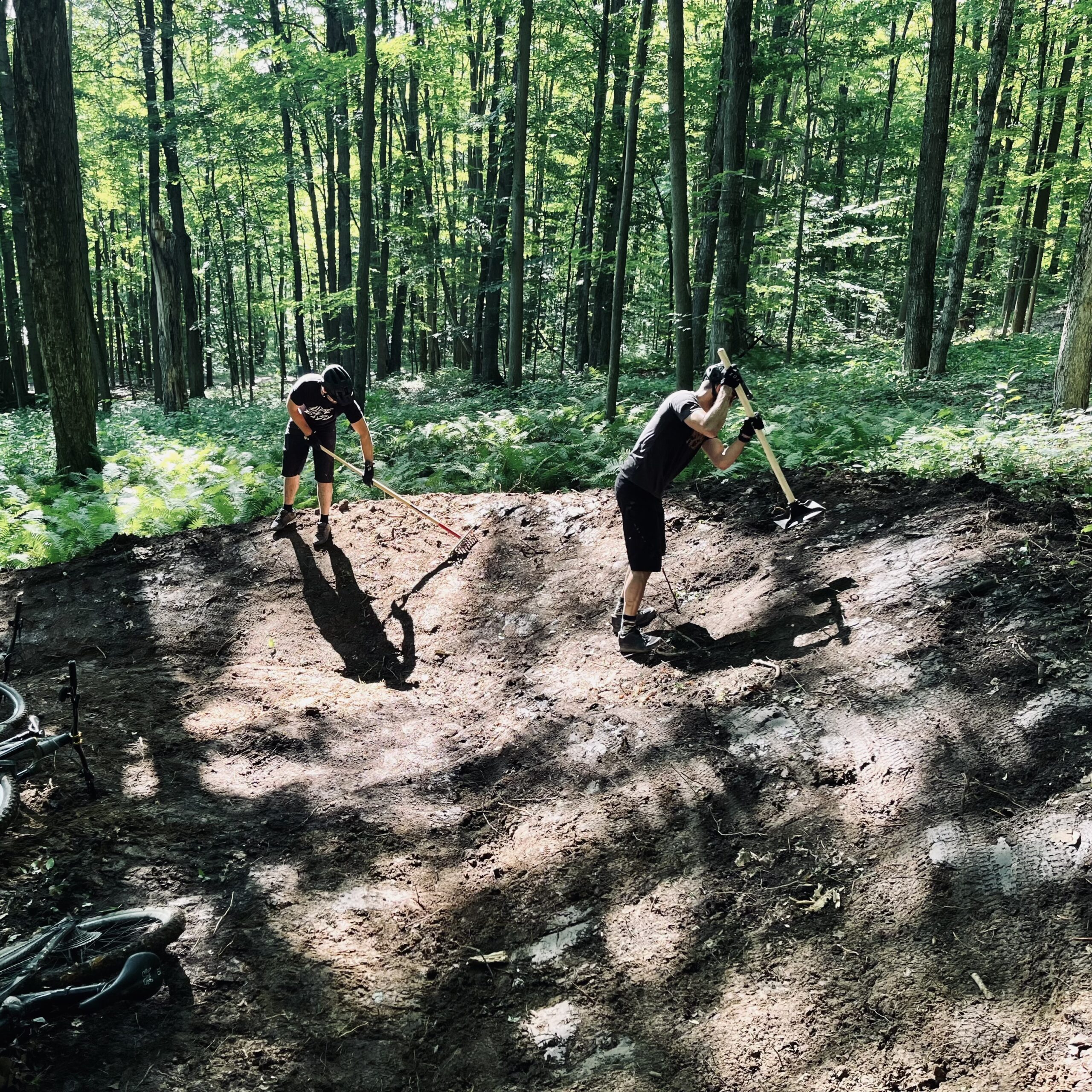 shoveling and packing berm on mountain bike trail